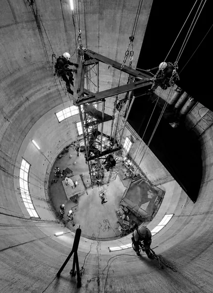 Cordistes d'Atout Vertical suspendus à l'intérieur d'un silo, autour d'une charge en cours de levage